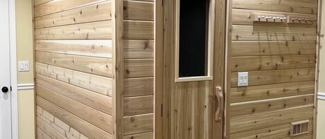 Ein Zimmer mit Holzwandverkleidung, einer weißen Tür und einem weißen Teppich auf dem Boden.