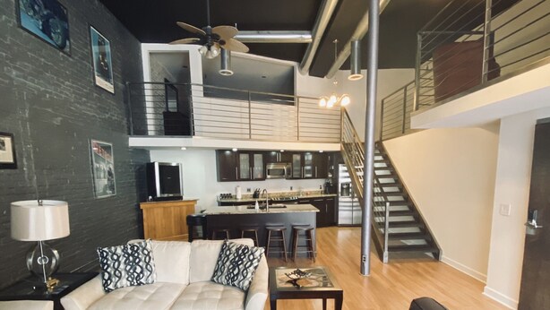 Un salon moderne avec un canapé, une table basse et un coin repas agrémenté d’un escalier.