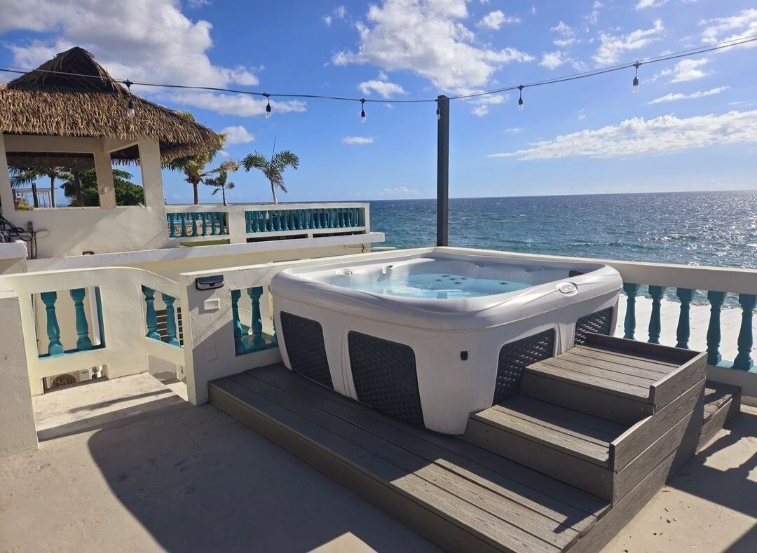 A hot tub on a deck with a view of the ocean.