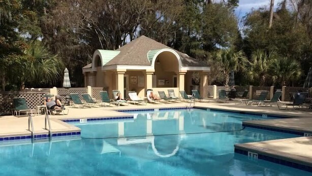 A swimming pool with lounge chairs and a covered pavilion. - PANORAMIC GOLF LAGOON VIEW,WALK TO BEACH, BEACH LOCKER,FROM OWNER,NO HIDDEN FEES (Hilton Head Island)