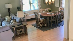 Una sala de estar con un sofá, una mesa de centro y un comedor con una mesa y sillas.
