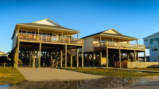 A two-story house with a balcony and a covered porch.
