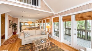 A spacious living room with a sofa, coffee table, and large windows with blinds. - Family Favorite 'Walker House' in Grayton Beach-Private Pool (Santa Rosa Beach)