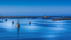 A calm harbor with several boats anchored near a breakwater. - Stunning Oceanview Coastal Home – Beach, Trails, Family Activities (Montara)