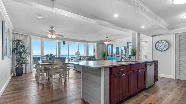 Una cocina amplia con una isla grande, piso de madera y vistas al exterior.