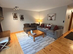 A living room with a sofa, a coffee table, and a lamp.
