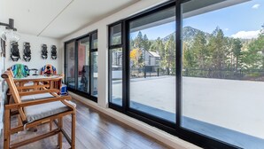 Una habitación amplia con ventanas grandes, un banco de madera y una mesa con varios objetos.