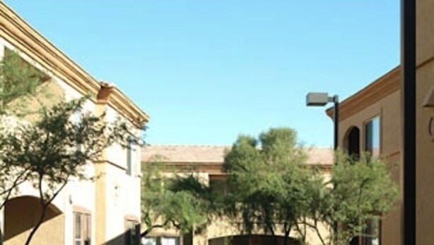 Un patio con edificios, árboles y cielo despejado.
