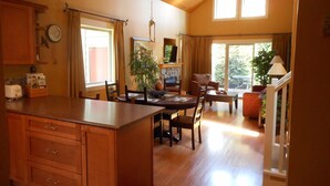 A spacious kitchen with wooden cabinets, a dining area with a table and chairs, and a living room with a sofa and a coffee table.