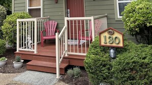 A two-story house with a front porch, a red door, and a mailbox.