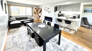 Ein moderner Wohnraum mit Essbereich, Küche und Treppe.
