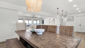 A spacious kitchen with a wooden island, white walls, and a view to the outdoors.