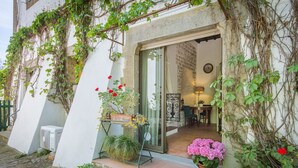 A building entrance with a glass door, potted plants, and a small outdoor seating area. - Beautiful Villa, in Florence, shared pool, 12 guests, wifi, parking (Firenze)