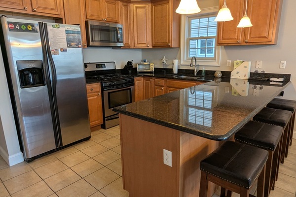 Beautiful modern kitchen with huge island and stainless steel appliances.