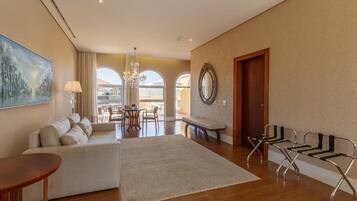 Un salón amplio con sofá, una mesa redonda, un banco y una chaise lounge.