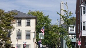 A street view with buildings, a flag, and street signs. - Historic Home At Freedom Trail (Boston)