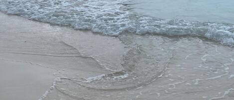 Une plage où les vagues douces viennent lécher le rivage.