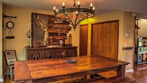 A rustic dining area with a wooden table and benches, a chandelier, and a wall-mounted clock. - Hendersonville Ranch Getaway that is just 30 minutes from Music City (Hendersonville)