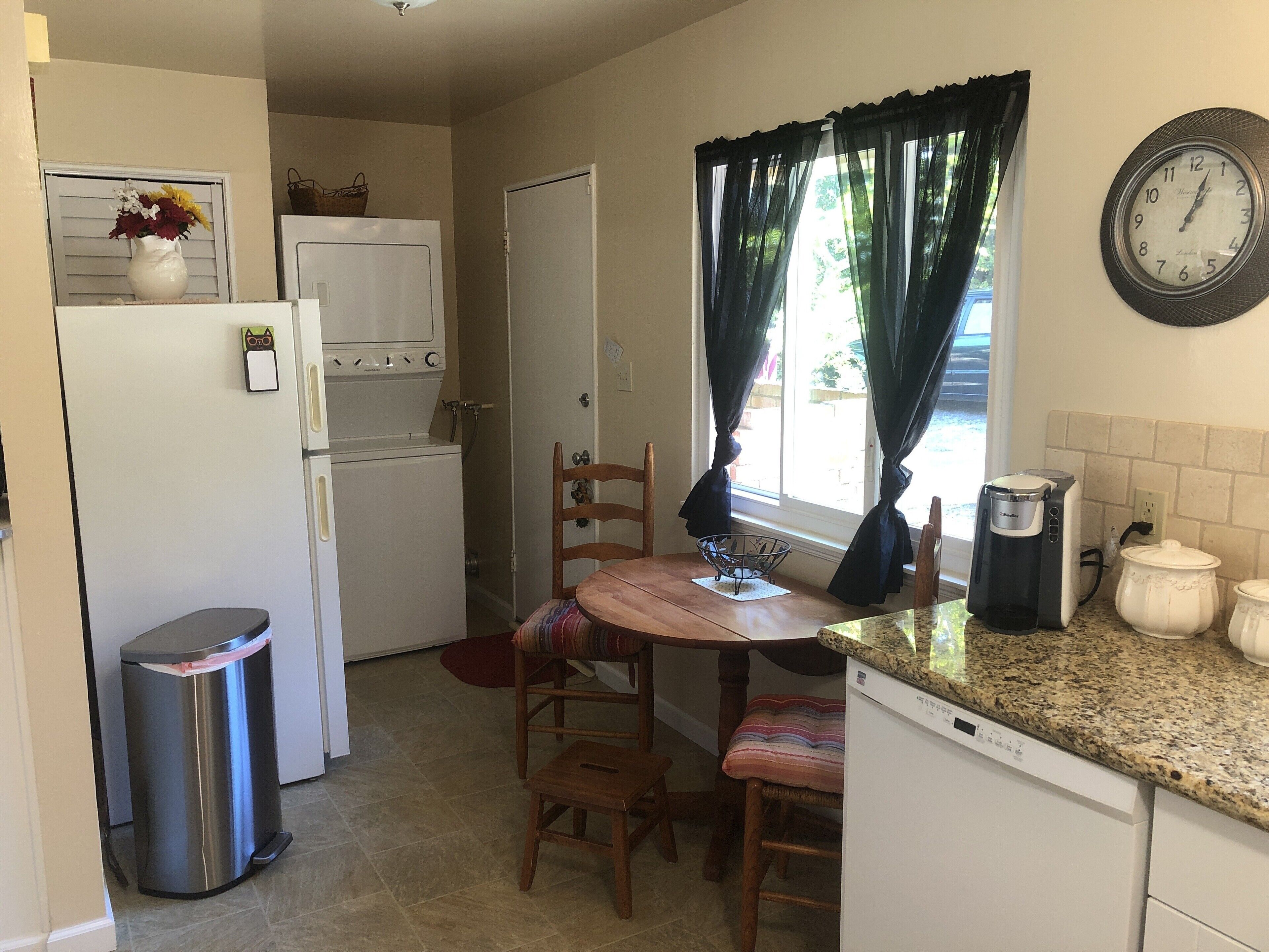 Una cocina compacta equipada con refrigerador, estufa y cafetera.
