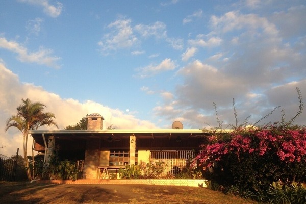 Front view of left half, stepless entry to porch is near the palm tree on left