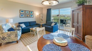 A living room with two sofas, a dining table with placemats, a chandelier, and a view of the outdoors. - Beautiful Beach View Condo!  1 Bedroom, Bunk room and 2 bath (Miramar Beach)
