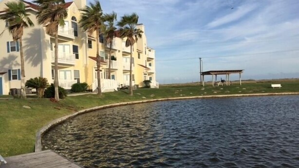 Un edificio residencial con piscina, quiosco y zona verde.