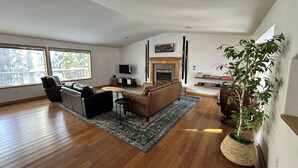 Un salon spacieux doté d’une cheminée, d’un téléviseur et d’une grande fenêtre.