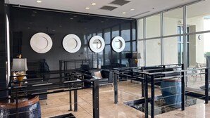 A modern lobby with a glass wall, black furniture, and decorative plates on the wall. - Sterling Breeze 1704! 2 Master Suites, Beachfront, Beach Chair Svc Incl! (Panama City Beach)