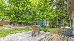 A wooden deck with outdoor furniture, a small table, and chairs. - Frances Cottage - Walking distance to downtown Saugatuck! Large backyard! (Saugatuck)