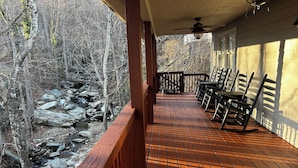A wooden deck with a view of a rocky stream and trees. - Relaxing retreat on Otter Falls with views of Grandfather Mountain. (Seven Devils)