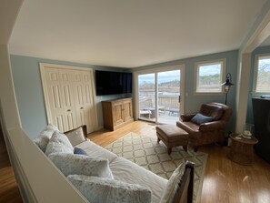 Relax in this spacious living room with a sofa, armchair, and flat-screen TV.