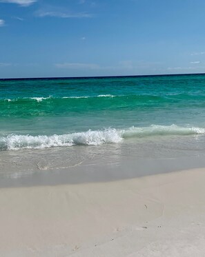 Ein Strand mit klarem, türkisblauem Wasser und einem sandigen Ufer.