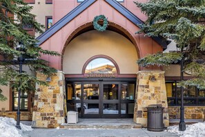 Entrada de un hotel con fachada de piedra, un gran arco de entrada y un cartel que dice 'CHATEAUX'.