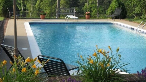 A swimming pool with a metal deck, surrounded by potted plants and flowers. - Private Paradise -  Historic 1870 Home on 630 Acre Estate - Pool, Lake, Views (Goochland)