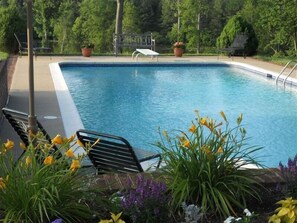 A swimming pool with a metal deck, surrounded by potted plants and flowers. - Private Paradise -  Historic 1870 Home on 630 Acre Estate - Pool, Lake, Views (Goochland)