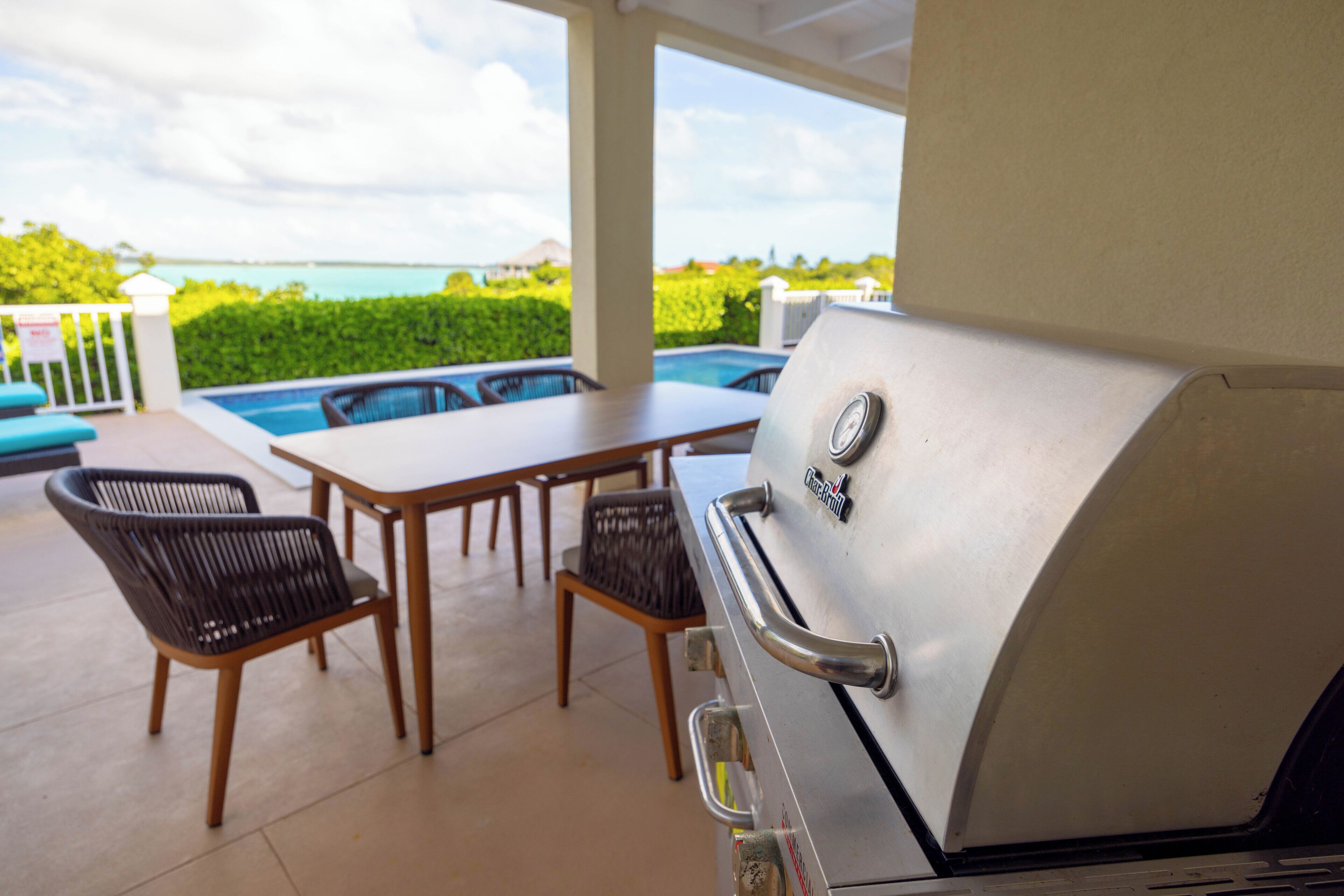 Un pati amb una barbacoa, una piscina i vista a l'oceà.