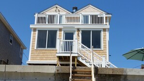 Une maison à deux étages dotée d’un balcon et d’un escalier menant au deuxième étage.