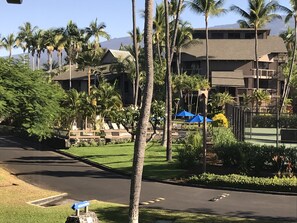 Experience the resort's modern design, featuring balconies and communal spaces, amidst lush tropical surroundings and well-manicured lawns.