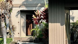 A modern building with a wooden exterior, a door, and a small porch area. - Oceanfront Paradise Kanaloa at Kona Condo
AC Stunning Ocean Views & Sunsets (Kailua-Kona)