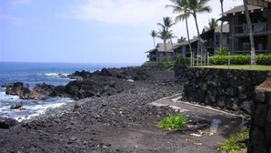 A coastal hotel with a rocky shoreline, palm trees, and ocean views. - Oceanfront Paradise Kanaloa at Kona Condo
AC Stunning Ocean Views & Sunsets (Kailua-Kona)