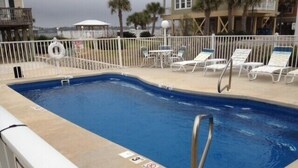 A swimming pool with lounge chairs and a lifebuoy. - Hobbie's Hideaway - Fall Dates Available (Gulf Shores)