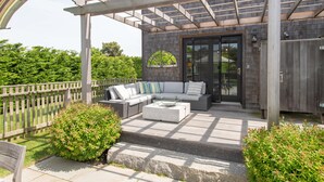 Eine Terrasse im Freien mit einer eingebauten Sitzecke, einem Couchtisch und einer Pergola.