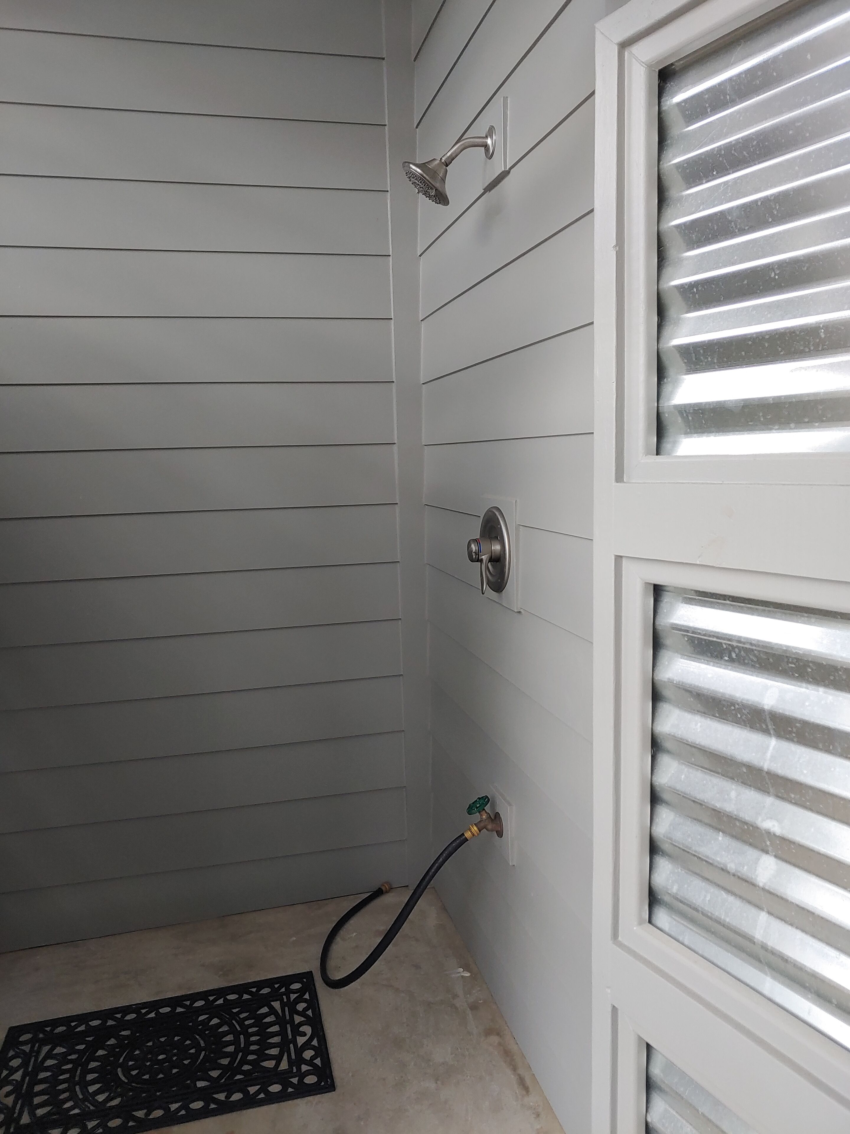 A bathroom with a shower, a toilet, and a sink.