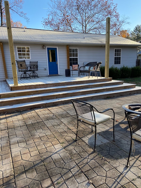 A house with a porch, outdoor seating, and a blue door.