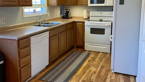 A kitchen with wooden cabinets, a dishwasher, a microwave, an oven, and a refrigerator. - Quiet, Cozy, and Family Friendly in Hendo (Hendersonville)