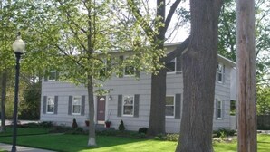 A two-story building with a front entrance, a sidewalk, and a well-maintained lawn.