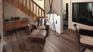 A spacious living area with a high ceiling, wooden staircase, leather furniture, and a large window. -  PARK CITY CANYONS VILLAGE - LUXURY CONDO. ONE OF THE BEST LOCATIONS POSSIBLE, (Park City)