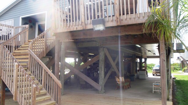 A wooden deck with a staircase leading to a covered area. - Family Owned Waterfront 3 Bedroom/2 Bath Fully Furnished Condo (Venice)