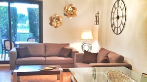 Una sala de estar con un sofá, una mesa de centro de vidrio y una lámpara.