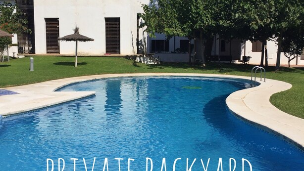 Patio privado con una piscina grande y un portón que da a ella.